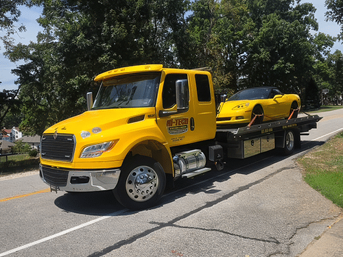 towing a corvette on a flatbed truck